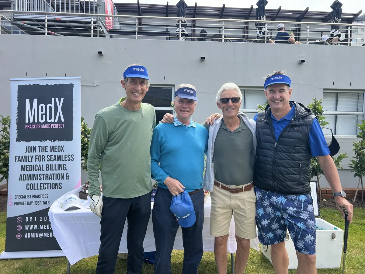 Four golfers in medx visors beside a MedX banner at a golf day