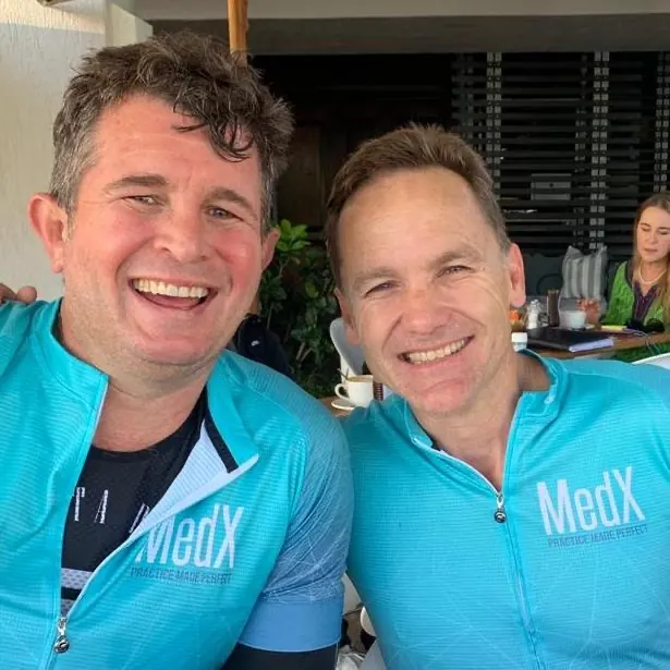 Ian and Dion smiling in their MedX cycling tops